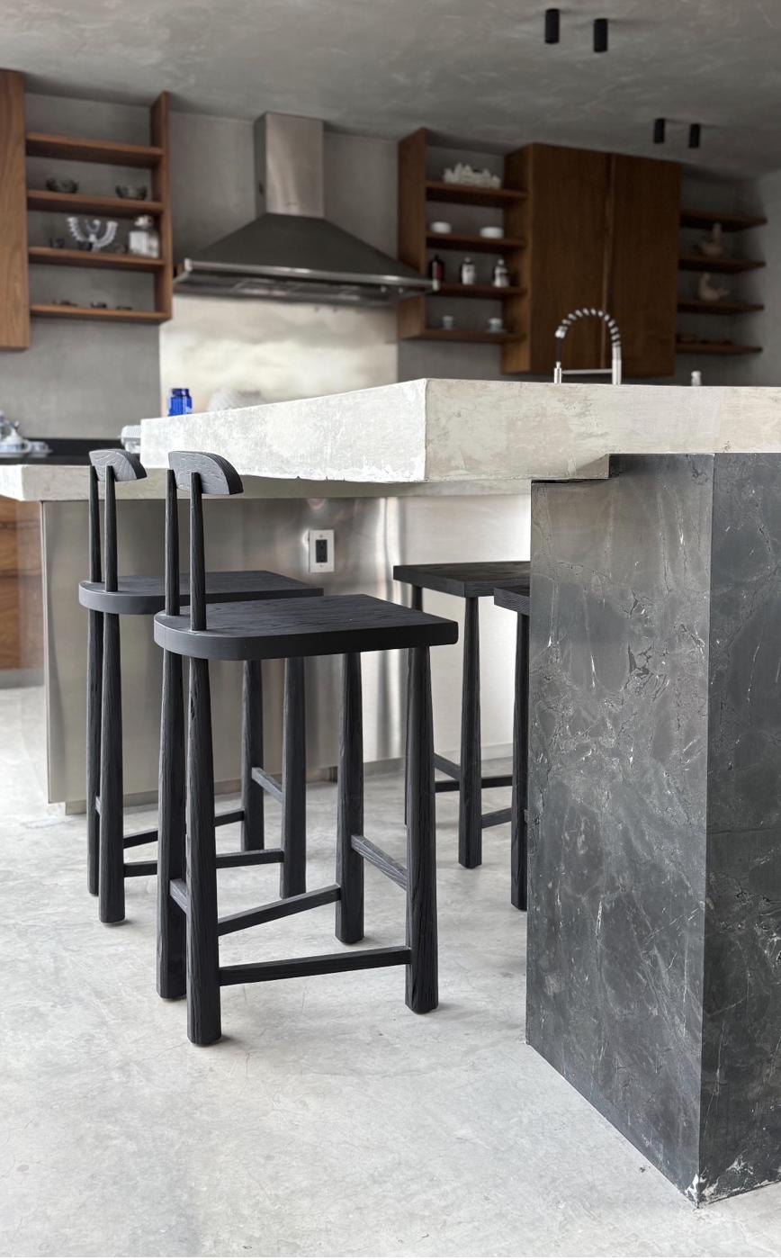 Bancos altos PE en cocina con barra de concreto y mármol